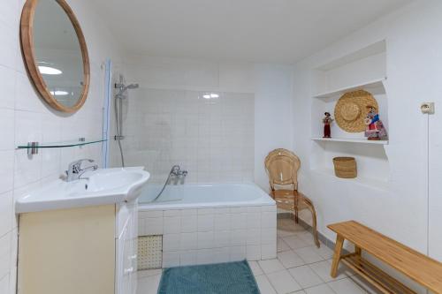 une salle de bain avec une baignoire, un lavabo et un miroir dans l'établissement Paradou de saint Joseph Bastide provençale piscine, à Brignoles