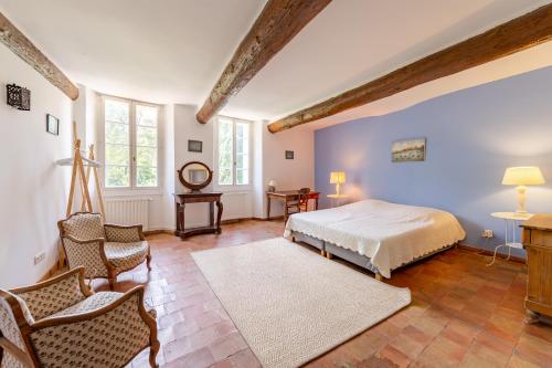 une chambre avec un lit, une table et des chaises dans l'établissement Paradou de saint Joseph Bastide provençale piscine, à Brignoles