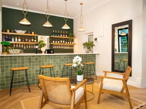 a bar with chairs and a table in a room at One Kensington Boutique Hotel in Cape Town