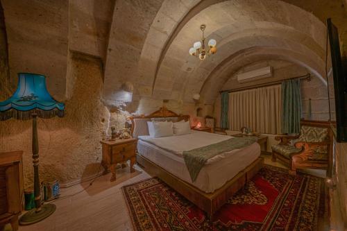 a bedroom with a bed in a stone room at Gamirasu Village House in Nevsehir