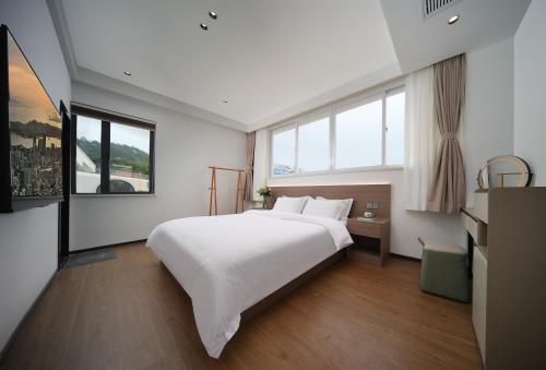 a bedroom with a large white bed and windows at 贵客心宿 Xiamen Guike Xinsu in Xiamen