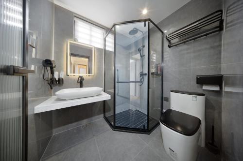 a bathroom with a sink and a shower and a toilet at 贵客心宿 Xiamen Guike Xinsu in Xiamen