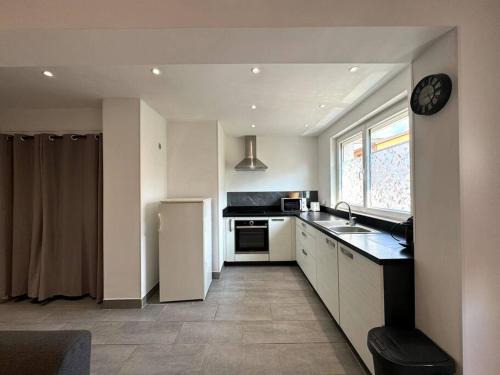 une cuisine avec un réfrigérateur blanc et une fenêtre dans l'établissement Maison de village, garage & climatisation, à Les Roches-de-Condrieu