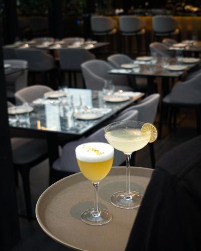 two glasses of drinks sitting on a table at B Hotel Kuala Lumpur in Kuala Lumpur