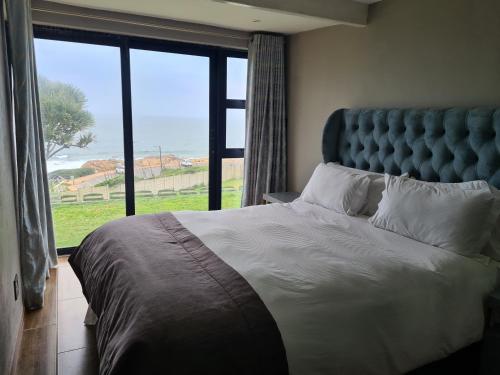 a bedroom with a large bed with a large window at Beach House Margate in Margate