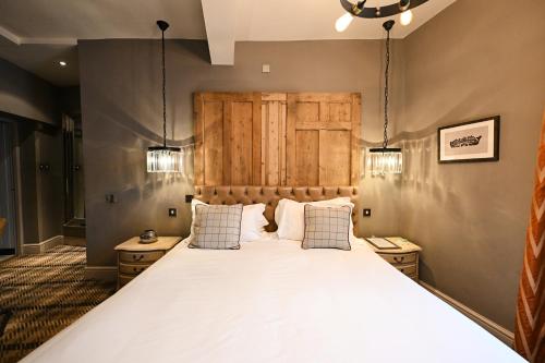 a bedroom with a large bed with two pillows at The King's Head in Beverley