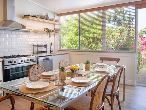 a kitchen with a glass table and chairs and a kitchen with a stove at One Kensington Boutique Hotel in Cape Town