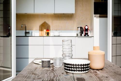 a kitchen with a wooden table with a bowl and cups at Florizand - Ecohuisjes Terschelling in Midsland