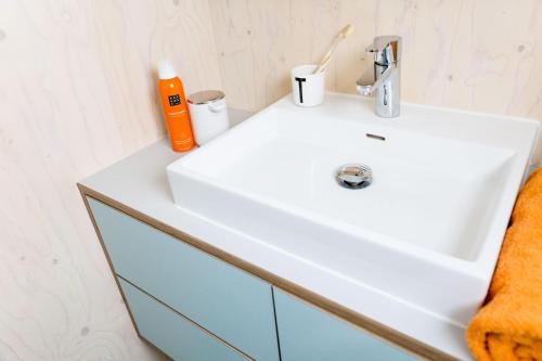 a bathroom with a white sink and an orange towel at Florizand - Ecohuisjes Terschelling in Midsland
