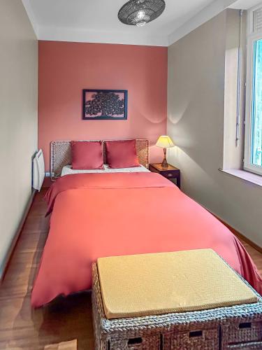 - une chambre avec un grand lit et des draps rouges dans l'établissement L'Escapade de Roubaix, à Roubaix