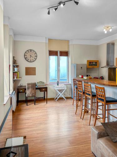 - un salon avec une table, des chaises et une horloge dans l'établissement L'Escapade de Roubaix, à Roubaix