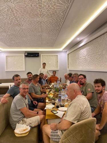 a group of people sitting around a table at Hotel Kasbah Ennakhile in Nkob