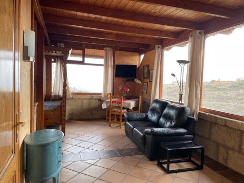 a living room with a leather couch and a table at Bergfincahäuschen in Santa Cruz de Tenerife