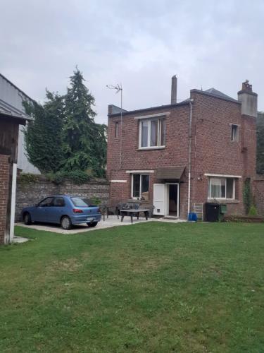 a car parked in front of a brick house at Chez Vincent, Chambres doubles équipées, avec accès privé, très bon emplacement dans Dieppe, au calme, avec Parking Gratuit et Clôturé, terrasse et grand jardin, simple et convivial, Animaux admis in Dieppe