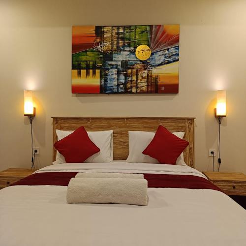 a bedroom with a large bed with red pillows at Prayoga homestay in Nusa Dua