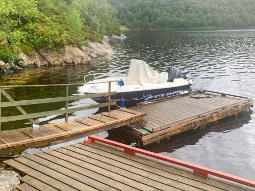a boat is docked at a dock on a lake at 6 person holiday home in Ånneland-By Traum in Ånneland