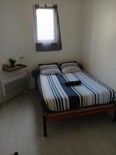 a bed in a small room with a window at Chez Vincent, Chambres doubles équipées, avec accès privé, très bon emplacement dans Dieppe, au calme, avec Parking Gratuit et Clôturé, terrasse et grand jardin, simple et convivial, Animaux admis in Dieppe