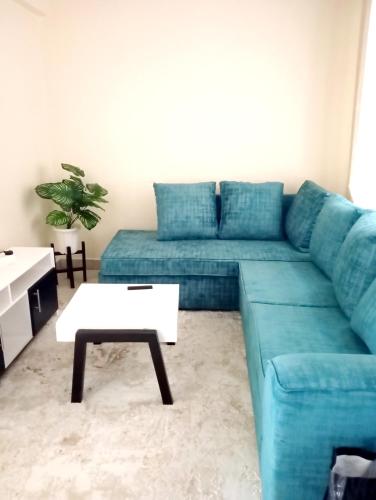 a living room with a blue couch and a coffee table at Attique homes in Makandara