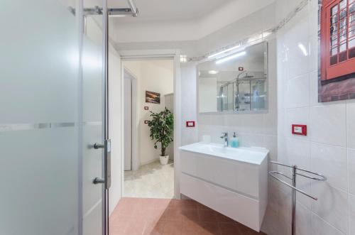a white bathroom with a sink and a mirror at Residence Daytona Appartamento due camere in Caorle