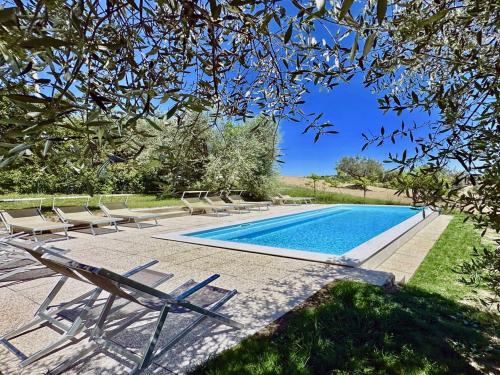 a swimming pool with chaise lounge chairs and a swimming pool at private spa in historic villa with pool in Senigallia in Senigallia