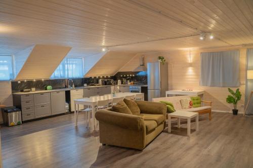 a living room with a couch and a kitchen at Majutus Massu Ratsaklubis in Massu