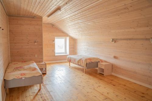 a bedroom with two beds in a room with wooden walls at Majutus Massu Ratsaklubis in Massu