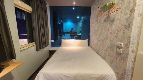 a small bedroom with a bed in a room at Yung Feng Hotel in Keelung