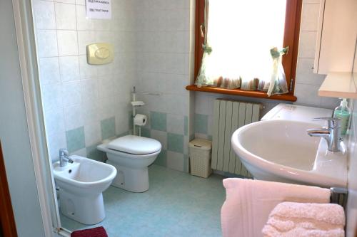 a bathroom with a sink and a toilet and a tub at Casa Fiorella - Appartamento - Parcheggio gratuito in Beccacivetta