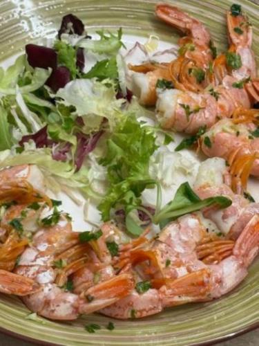 a green plate with shrimp and salad on it at B&B VillaDansio in Rezzoaglio