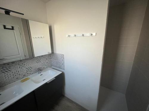 a white bathroom with a sink and a shower at maison 6-8 personnes, 300m de la plage in La Guérinière