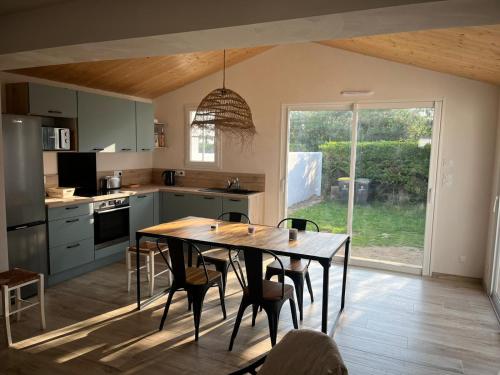 a kitchen with a wooden table and chairs in a room at maison 6-8 personnes, 300m de la plage in La Guérinière