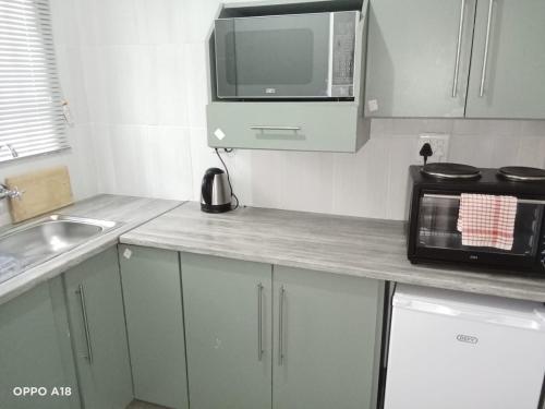 una piccola cucina con forno a microonde e lavandino di The View a Orkney