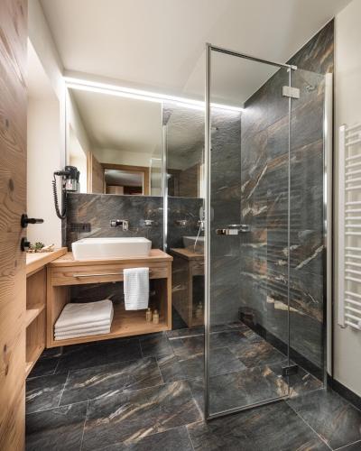 a bathroom with a shower and a sink at Hotel Alpenhof in Grossarl
