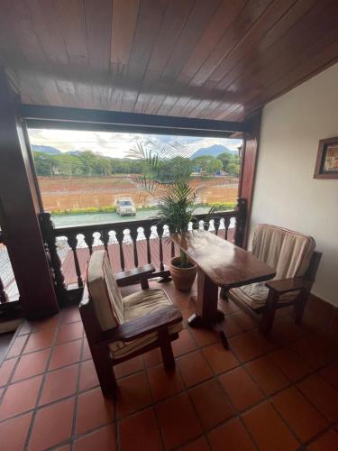 a room with a table and chairs and a large window at Luang Prabang - Villa Ouis Namkhan Riverside 2 in Luang Prabang
