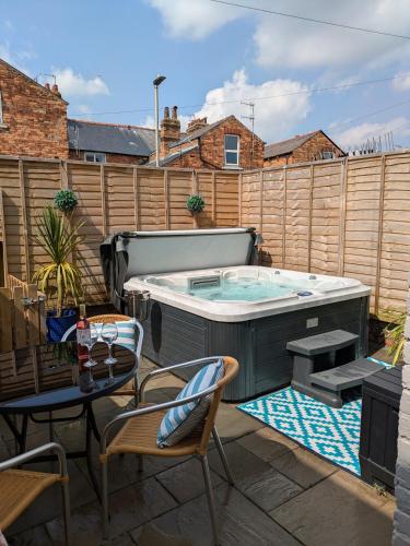 a hot tub on a patio with a table and chairs at Seaside Escapes - with relaxing hot tub! in Scarborough