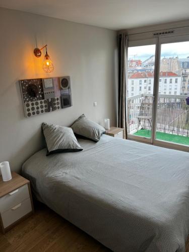 une chambre avec un lit et une grande fenêtre dans l'établissement Super 3 pcs et Parking aux portes de Paris et stade de france à proximité des sites touristiques parisiens Montmartre , champs Élysée ,châtelet etc et des transports métro,RER ,wifi disponible, à Saint-Ouen