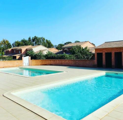une piscine avec de l'eau bleue dans une cour dans l'établissement Jaso - Maison à 5min de la plage, à Cervione