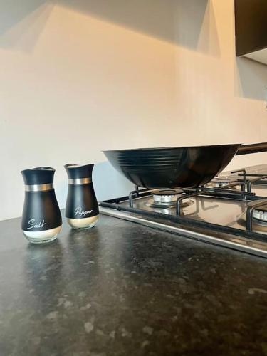 two black vases sitting on top of a stove at Haven Hideout 4 Bed With Sauna, Cinema & Gym in Royton