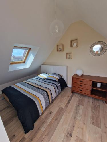 a bedroom with a bed and a dresser and a window at Le flamantNoir in Créances