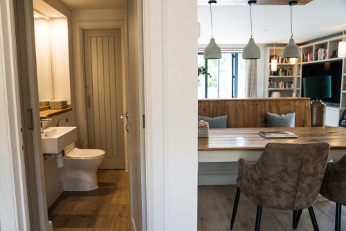 a kitchen and dining room with a table and chairs at Linhay Cottages 1 in Bathford