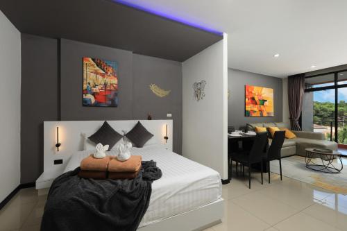 a bedroom with a bed and a dining room at 1bdr Spacious Studio near NaiHarn Beach by Capital Pro in Phuket Town