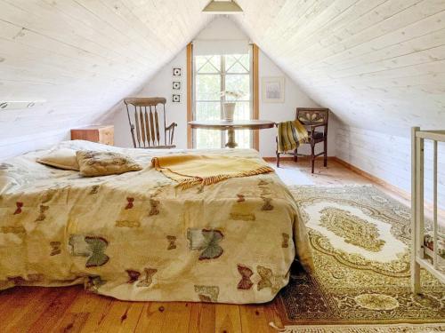 a bedroom with a bed and a table in a attic at 8 person holiday home in GOTLANDS TOFTA in Västergarn