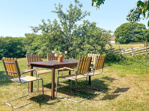 a wooden table with three chairs sitting around it at 8 person holiday home in GOTLANDS TOFTA in Västergarn