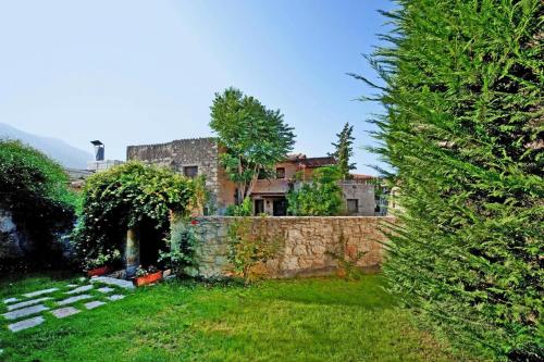 an old house behind a stone wall in a yard at Holiday home in the Archanes with a garden in Archanes