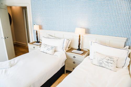 a bedroom with two beds with white sheets and pillows at Linhay Cottages 2 in Bathford