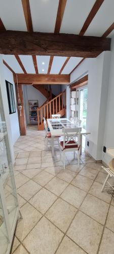 une salle à manger avec une table et des chaises blanches dans l'établissement La mare aux étoiles, à La Douze