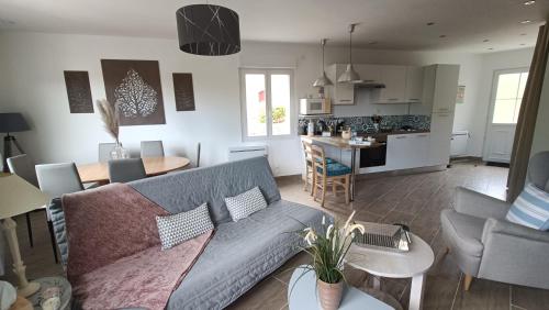 un salon avec un canapé et une cuisine dans l'établissement Les petites bulles, à Coupru