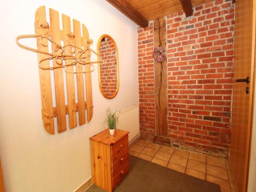 a hallway with a brick wall and a wooden cabinet at Reihenhaus in Strackholt mit beheiztem Pool in Strackholt
