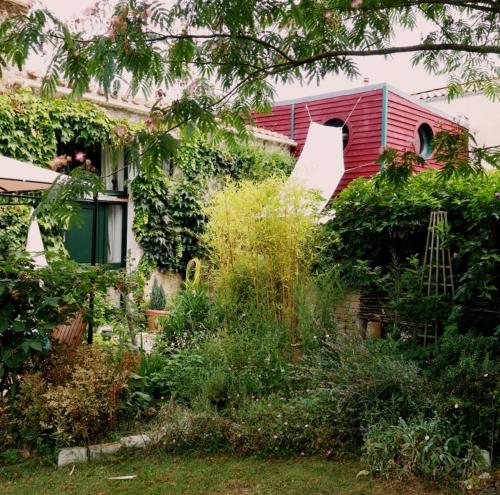 a house with a lot of plants in front of it at Maison du chat bleu in Saint-Hilaire-de-Clisson