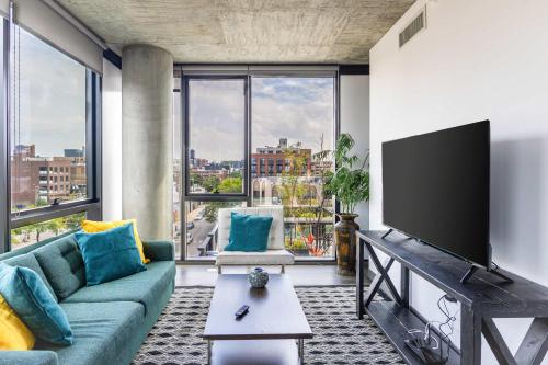 a living room with a couch and a flat screen tv at New Sleek 2BR - Perfect Blend of Comfort & Style in Chicago in Chicago